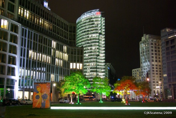 ￼Árvores e fachada do Ritz Carlton iluminadas para o Festival das Luzes, perto da Potsdamer Platz, com o prédio da DB iluminado em destaque